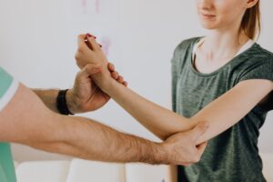 a therapist holding the elbow joint of a woman